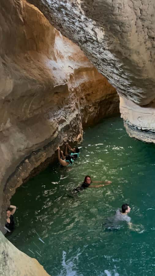 Muscat: Wadi Shab, Romantic Cave and Sinkhole Full-day Trip - Reaching the waterfall inside the cave